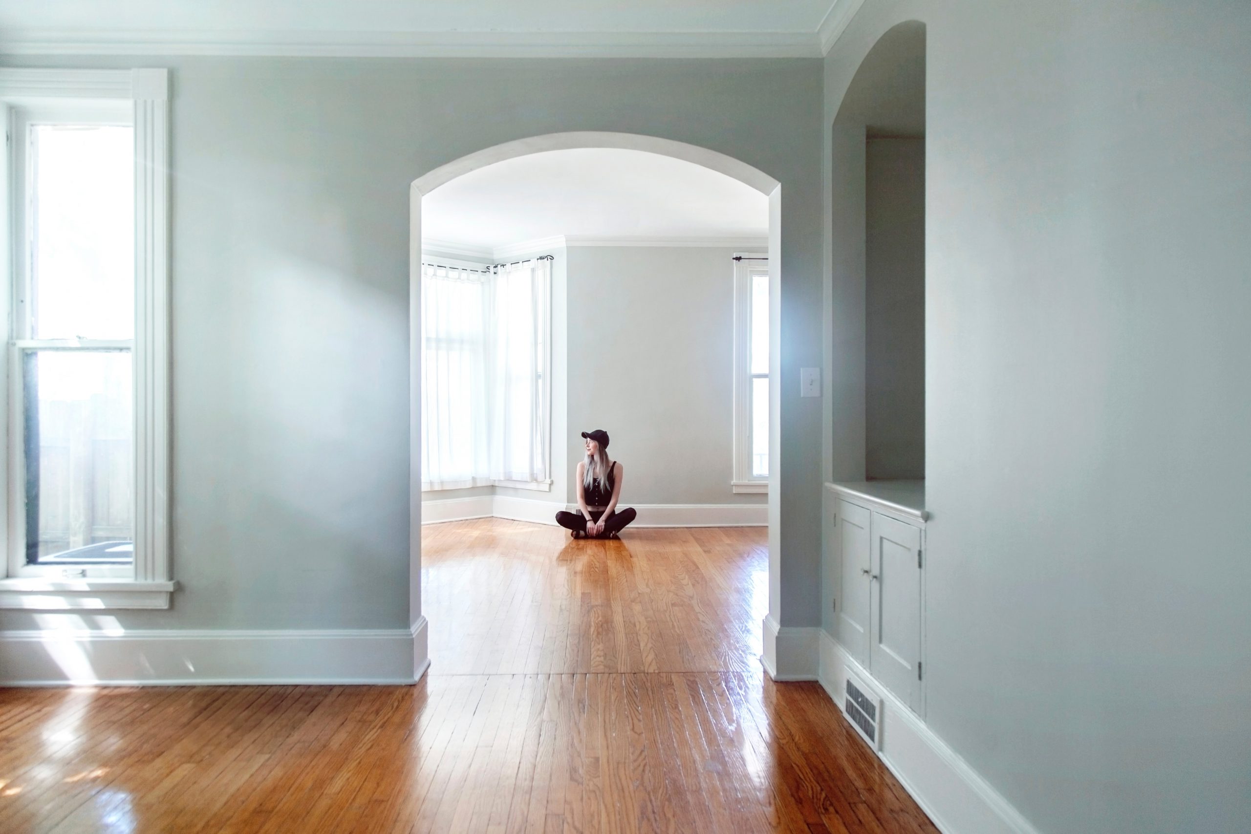 Image of a girl sitting inside a character home with wooden floors